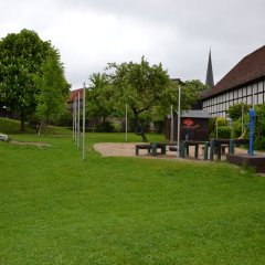 Garten der Kindertagesstätte mit Rasen und Spielgeräten
