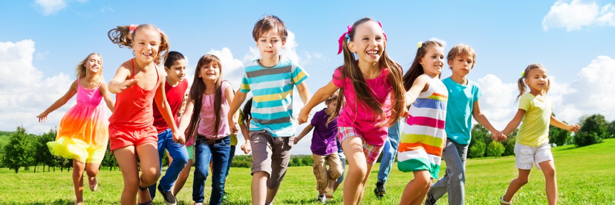 Rennende Kinder mehrere Kinder die über eine Wiese laufen