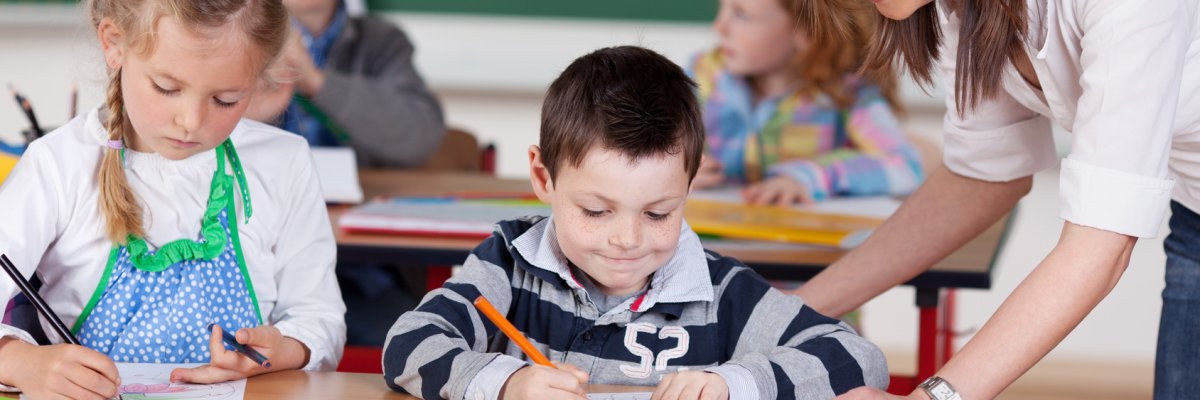 Lehrerin in der Grundschule Lehrerin und Schüler in der Grundschule