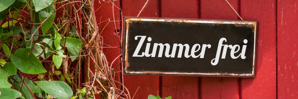 Schwarzes Blechschild mit Aufschrift Zimmer frei