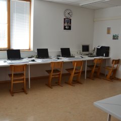 Computerraum mit Laptops, Tischen und Stühlen